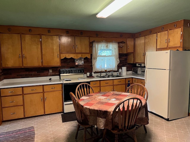 kitchen featuring decorative backsplash, white appliances, and sink