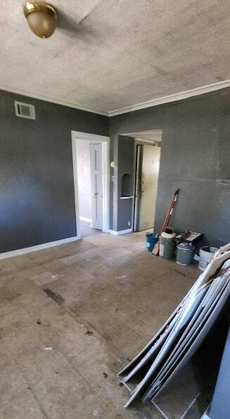 unfurnished living room with crown molding