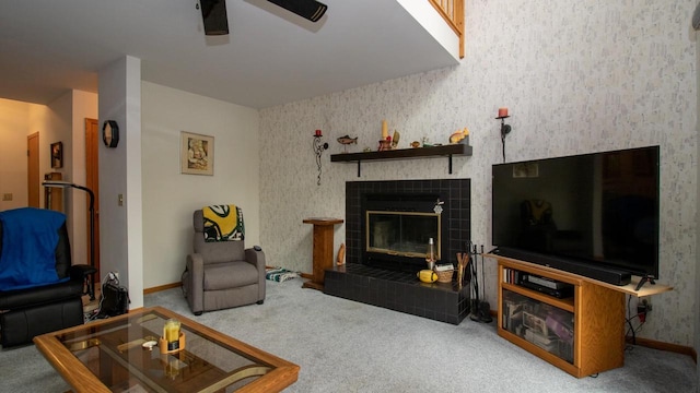 living room featuring ceiling fan, carpet floors, and a tile fireplace