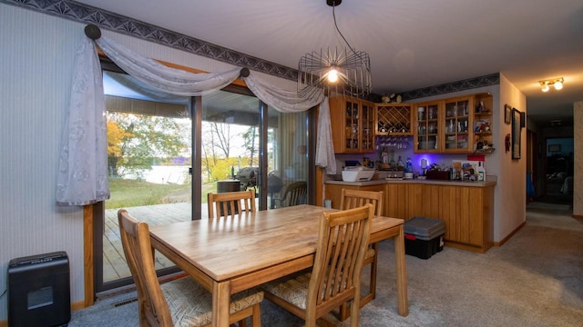 carpeted dining area featuring an inviting chandelier