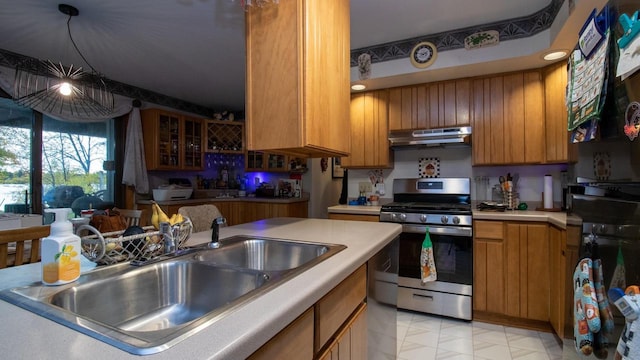 kitchen featuring hanging light fixtures, sink, ventilation hood, a notable chandelier, and stainless steel range with gas cooktop