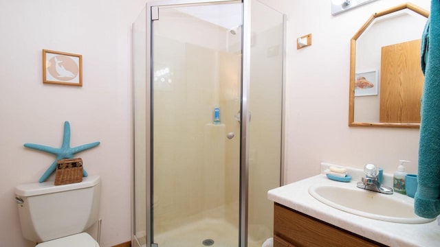 bathroom featuring an enclosed shower, vanity, and toilet