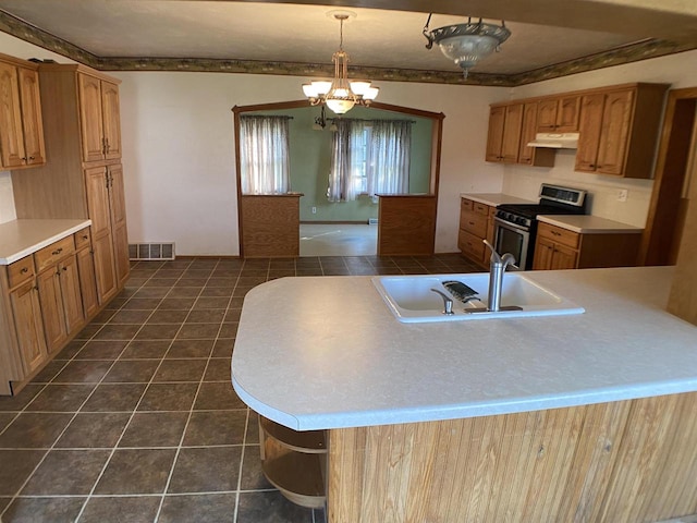 kitchen featuring dark tile patterned flooring, sink, a notable chandelier, stainless steel stove, and decorative light fixtures