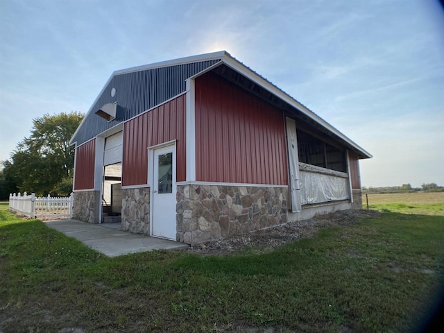 view of home's exterior with a lawn and an outbuilding