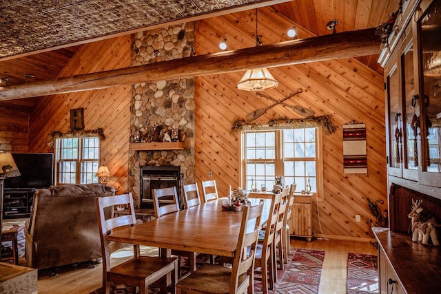 dining room featuring wooden walls, hardwood / wood-style floors, and a wealth of natural light