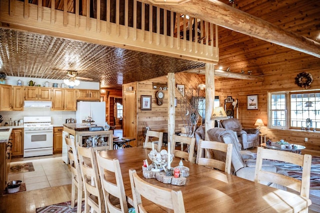 dining room featuring wood walls and light tile patterned flooring