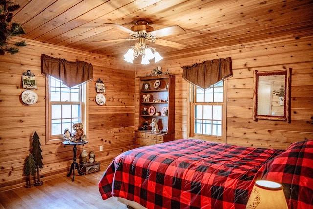 bedroom featuring ceiling fan, hardwood / wood-style flooring, wood walls, and wooden ceiling