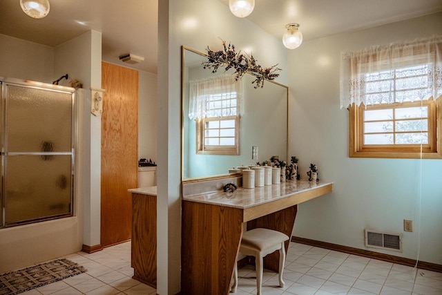 bathroom featuring vanity, combined bath / shower with glass door, and tile patterned floors