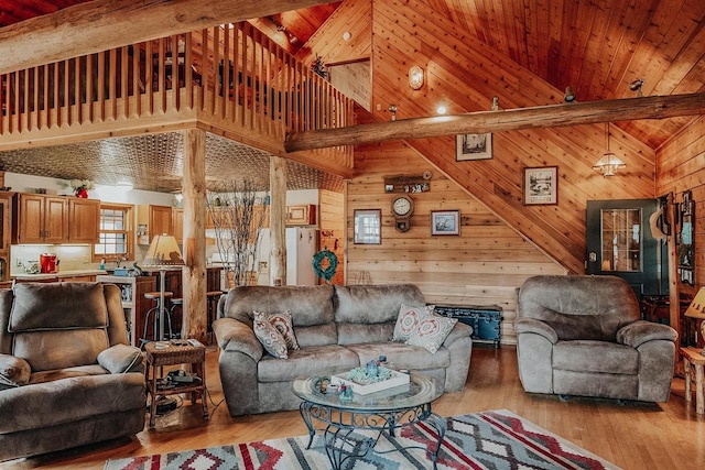 living room with wood walls, light hardwood / wood-style floors, and high vaulted ceiling