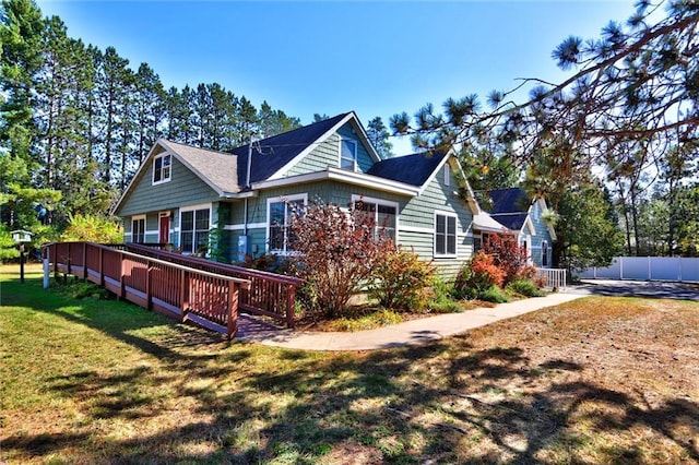 exterior space with a wooden deck and a lawn