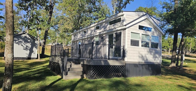 view of side of property featuring a lawn, a storage unit, and a deck