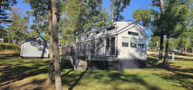 view of side of property featuring a lawn and a storage shed