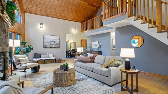 living room with high vaulted ceiling, light wood-type flooring, a fireplace, and wood ceiling