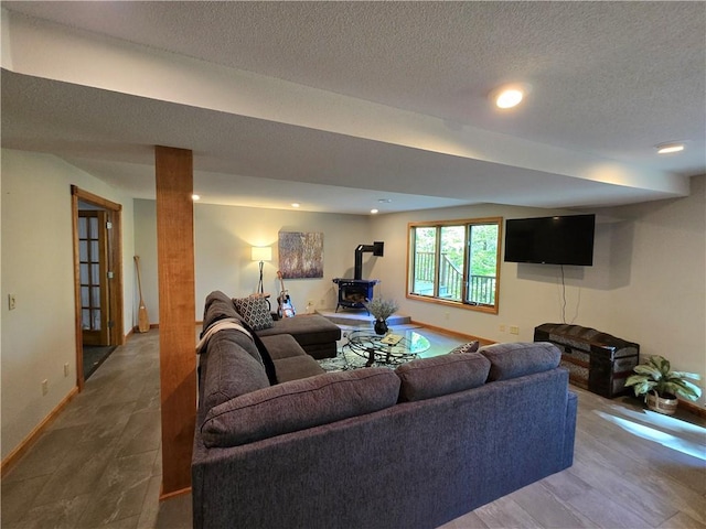 living room with a wood stove and a textured ceiling