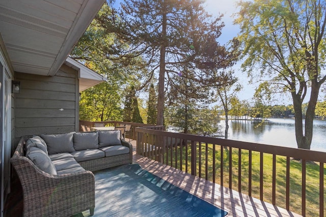 wooden deck with an outdoor living space, a lawn, and a water view