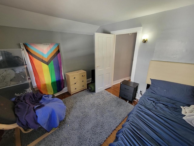 bedroom with lofted ceiling and dark wood-type flooring