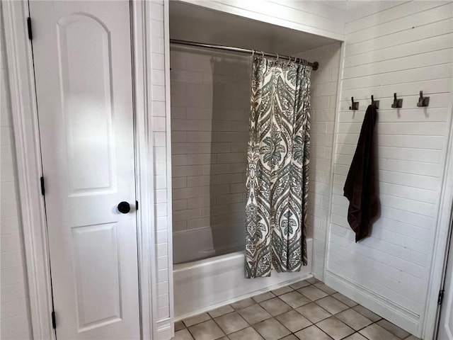 bathroom featuring tile patterned floors, shower / tub combo with curtain, and wood walls