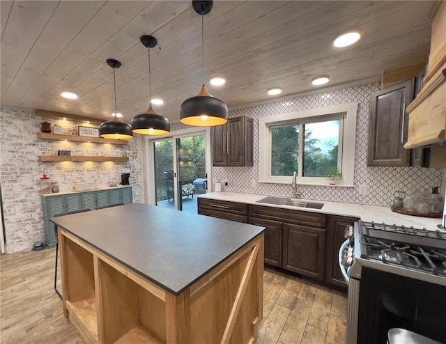 kitchen with light wood-type flooring, a healthy amount of sunlight, gas stove, and sink