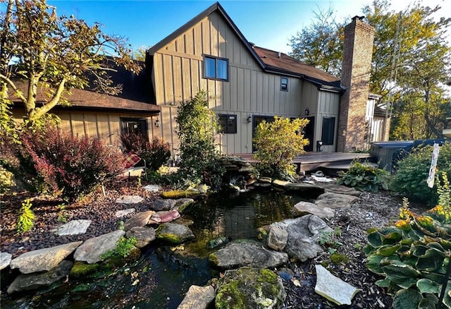 rear view of property with a small pond