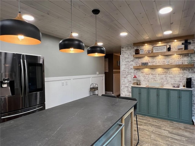 kitchen featuring hanging light fixtures, wood ceiling, stainless steel fridge, and hardwood / wood-style floors