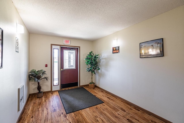 foyer entrance with hardwood / wood-style flooring and a textured ceiling