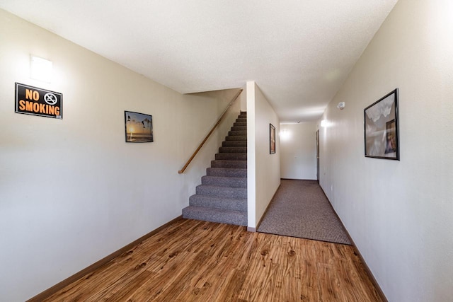 interior space with a textured ceiling and hardwood / wood-style floors