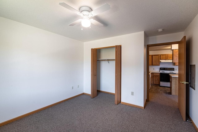 unfurnished bedroom with a textured ceiling, carpet, ceiling fan, and a closet