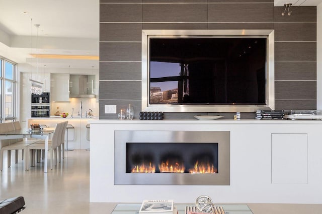 details featuring decorative backsplash and wall chimney range hood