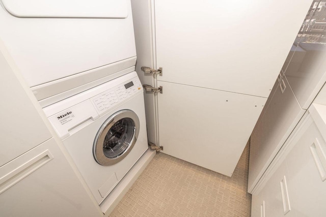 clothes washing area featuring stacked washer / dryer