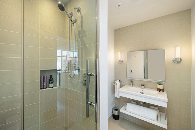 bathroom featuring tile walls, tile patterned floors, and a shower with shower door