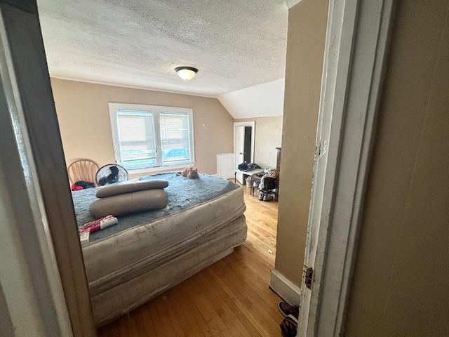 bedroom featuring light wood-type flooring and lofted ceiling