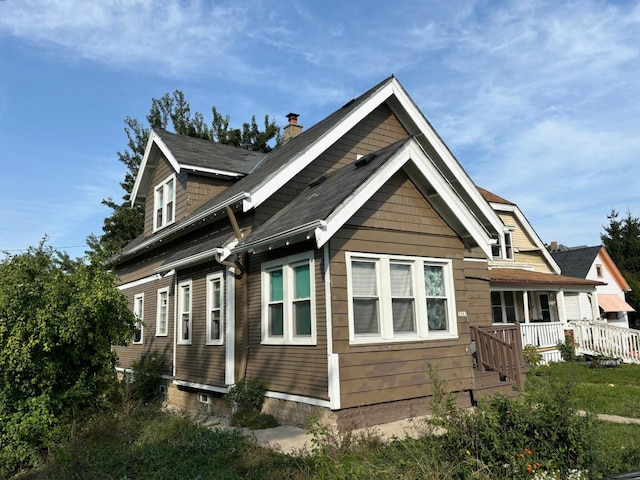 view of side of property featuring covered porch