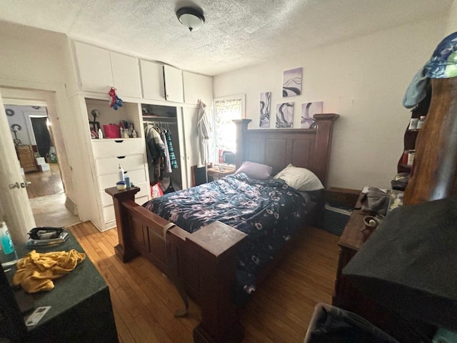 bedroom featuring hardwood / wood-style floors, a textured ceiling, and a closet