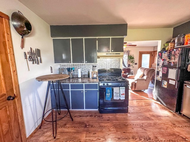 kitchen featuring dark wood-type flooring, tasteful backsplash, and black appliances