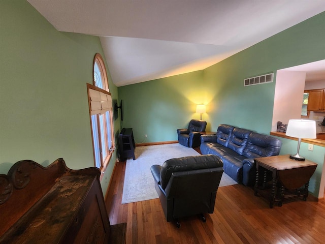 living room with vaulted ceiling and hardwood / wood-style floors