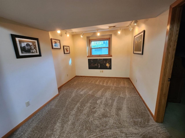 unfurnished room featuring carpet floors and track lighting