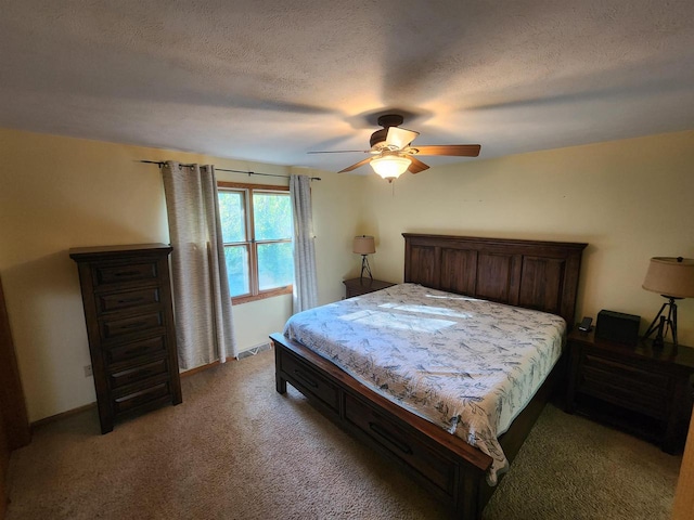 bedroom featuring ceiling fan, carpet floors, and a textured ceiling