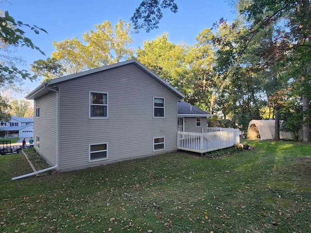 rear view of house featuring a lawn and a deck