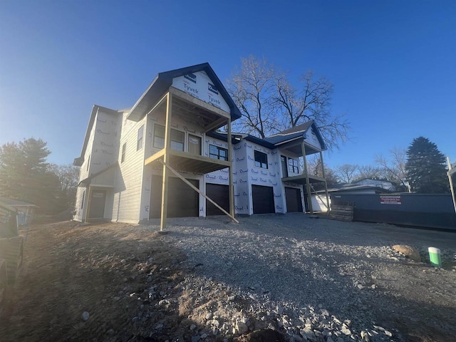 rear view of house featuring an attached garage and driveway