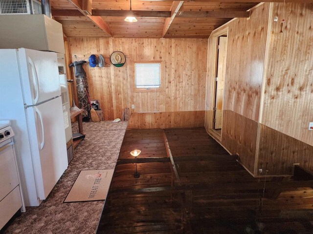 interior space with freestanding refrigerator, wood ceiling, wood walls, and visible vents