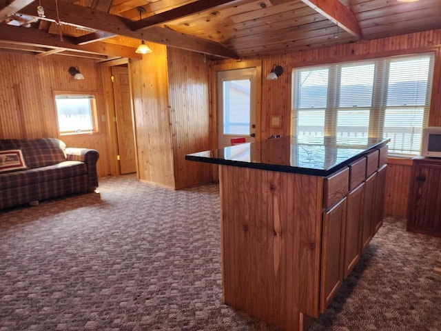 kitchen featuring wooden ceiling, beam ceiling, wooden walls, dark colored carpet, and dark countertops