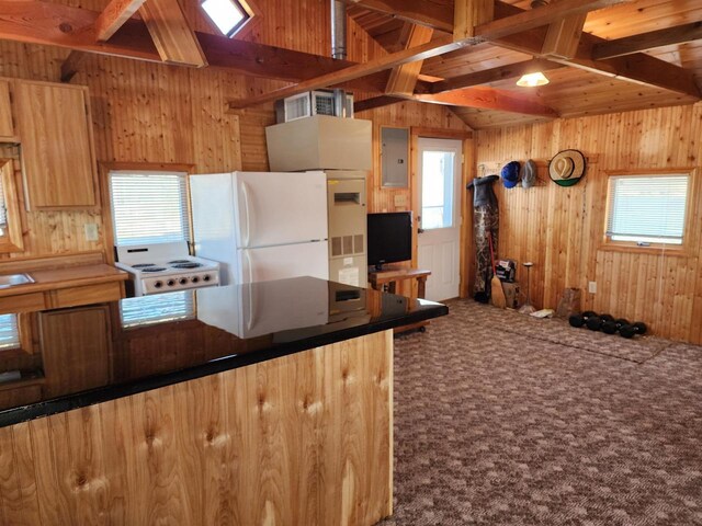 kitchen with electric panel, white appliances, wood walls, and carpet