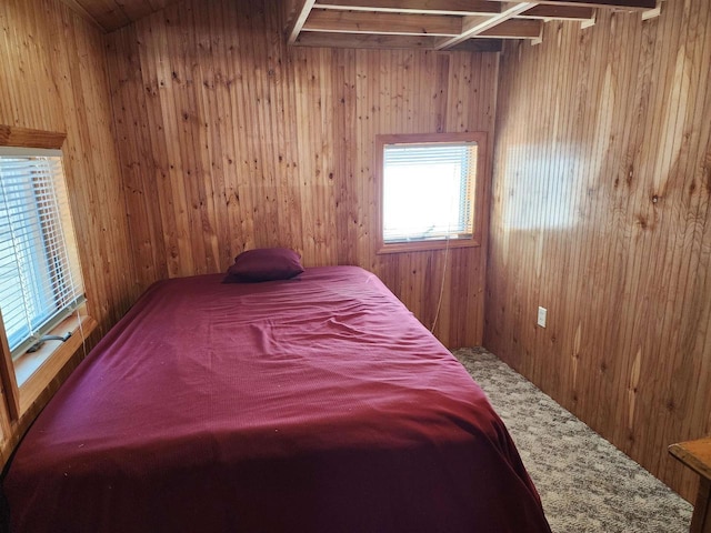 bedroom with carpet floors and wooden walls