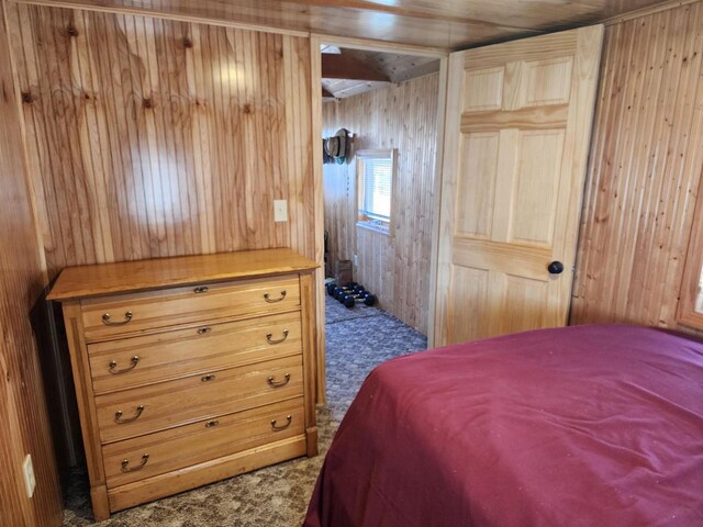 carpeted bedroom with wood walls