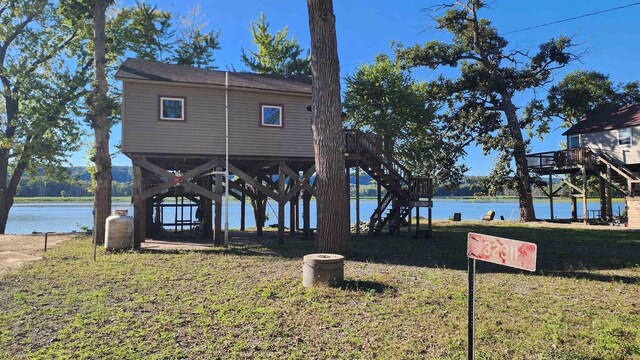 exterior space with a water view, stairway, and a yard