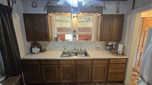 kitchen featuring ceiling fan, hardwood / wood-style flooring, stainless steel fridge, and sink