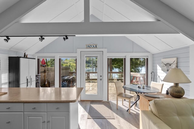 sunroom with lofted ceiling with beams and a wealth of natural light