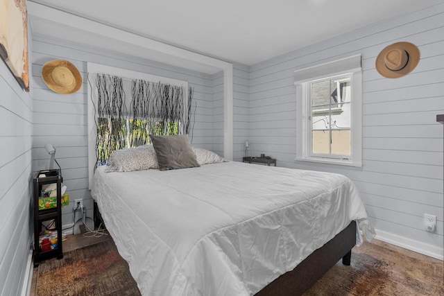 bedroom featuring wooden walls