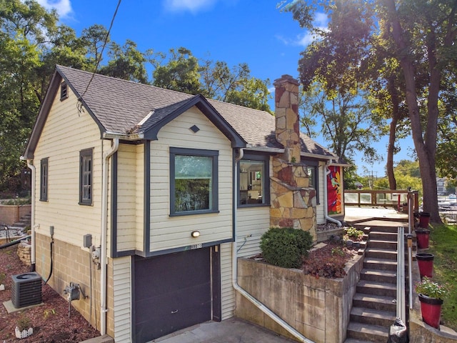 view of front of house with a garage and central AC unit