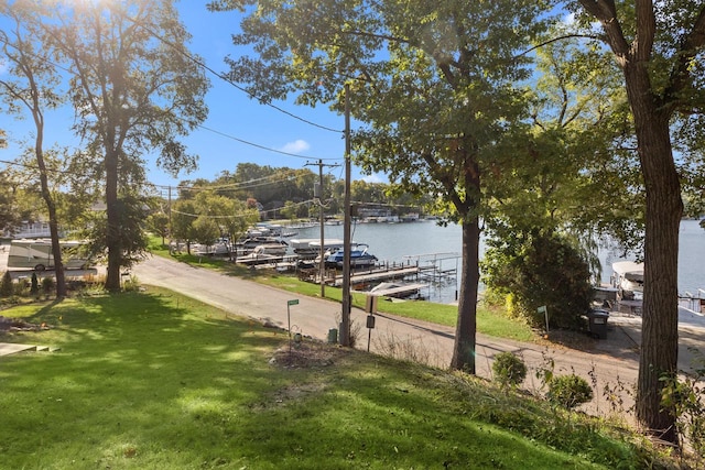 surrounding community with a yard and a water view